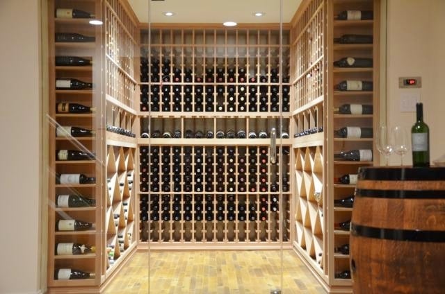 Custom Home Wine cellar with an Efficient Cooling unit, Elegant Wood Wine Racks, and Contemporary Glass Doors